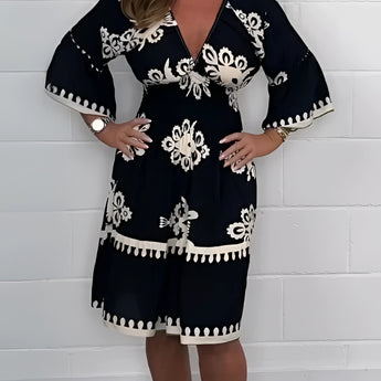 Plus size green V-neck boho summer dress with floral embroidery, featuring short sleeves and a relaxed fit. The dress is styled for a casual, comfortable look.