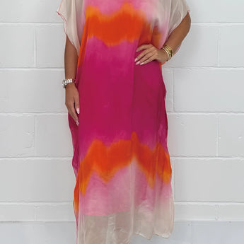 
A plus size tie-dye maxi kaftan beach cover-up in pink and orange, featuring batwing sleeves and a flowing design.