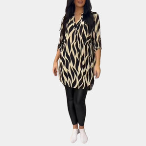 
A plus size zebra print V-neck tunic in yellow, featuring long sleeves and a high-low hem. The tunic is displayed in size 3XL, showcasing its stylish and comfortable fit.