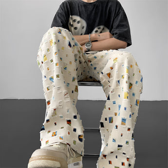 Polaroid Pattern Pants featuring a retro photo print design, styled as streetwear trousers. The pants are shown on a person, highlighting the fit around the waist, thighs, and knees.