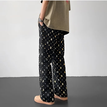 Polaroid Pattern Pants featuring a retro photo print design, shown in a Nero colorway and XXL size. The trousers display a unique and vibrant pattern, embodying a trendy streetwear style.