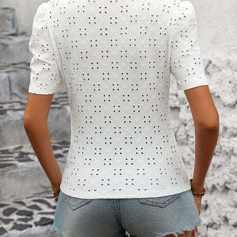 Woman wearing Polka Dot White Blouse Eva, a trendy summer casual chic fashion top, paired with shorts.