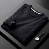 Premium men's blue sweater featuring a braided texture, ribbed cuffs, and cozy knit material, displayed on a wooden table.
