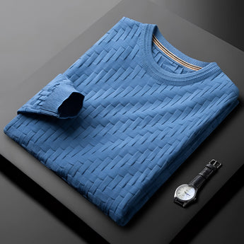 Premium men's blue sweater with braided texture, ribbed cuffs, and cozy knit, displayed on a grey wooden floor.