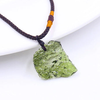 Raw Moldavite Healing Pendant in green tektite on a necklace, featuring natural materials and energy crystals.