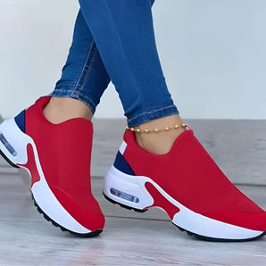 Red and blue women's breathable mesh slip-on sneakers, lightweight and fashionable, being worn on a person's feet.