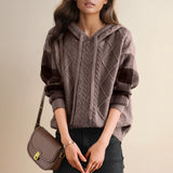 Red cable knit sweater with textured pullover design, featuring long sleeves and a round neckline.