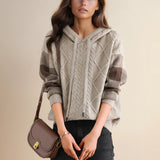 A fashion model wearing a red cable knit sweater with a luxurious textured design, featuring a round neck, long sleeves, and a fitted waist.