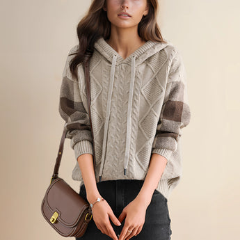 A fashion model wearing a red cable knit sweater with a luxurious textured design, featuring a round neck, long sleeves, and a fitted waist.
