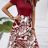 A model wearing a high-waisted red floral A-line skirt paired with a white top featuring green accents, highlighting the stylish and feminine design of the women's fashion outfit.