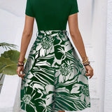 Red floral A-line skirt, part of a high-waisted women's fashion ensemble, featuring a vibrant floral pattern in red with green accents, suitable for day wear, displayed on a mannequin.