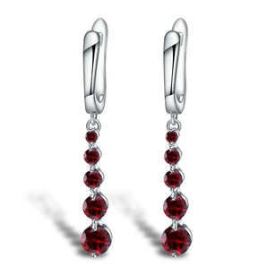 Elegant sterling silver dangle earrings featuring vibrant red gemstone drops, designed for luxury women's jewelry.