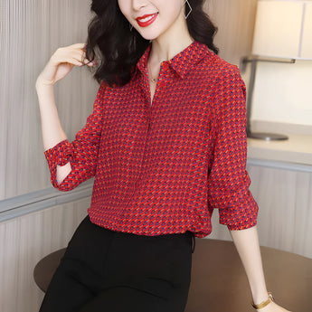 
A stylish red geometric print blouse with three-quarter sleeves, perfect for autumn fashion. The blouse features a classic tartan pattern and a comfortable fit, complementing the neck and shoulder area. The model is smiling, showcasing the blouse's appeal and versatility.