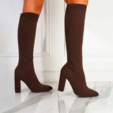 Red knee-high sock boots with high heels in ribbed fabric, styled for fashion, shown in a standing position on a human leg.