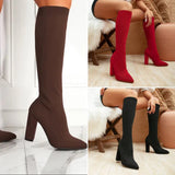 Red knee-high sock boots with high heels, featuring a ribbed fabric design, shown on a model's legs.
