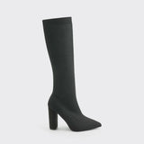 
A pair of red knee-high sock boots with high heels, featuring a ribbed fabric design, showcased on a model's legs. The boots are styled in a fashion-forward manner, emphasizing their sleek fit and modern appeal.