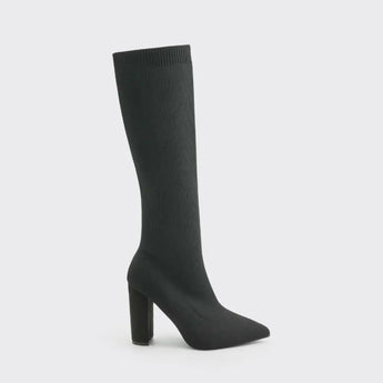 
A pair of red knee-high sock boots with high heels, featuring a ribbed fabric design, showcased on a model's legs. The boots are styled in a fashion-forward manner, emphasizing their sleek fit and modern appeal.
