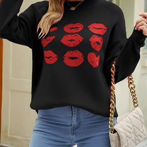 
A chic black pullover sweater featuring a bold red lip print design, worn by a model. The sweater is styled with eyewear and showcases a comfortable fit with visible shoulder and arm details.