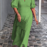 Green maxi dress with puff sleeves and a square neck, featuring studded pockets. The dress is styled for a 5XL size, depicted on a standing model, showcasing the dress's one-piece garment design.