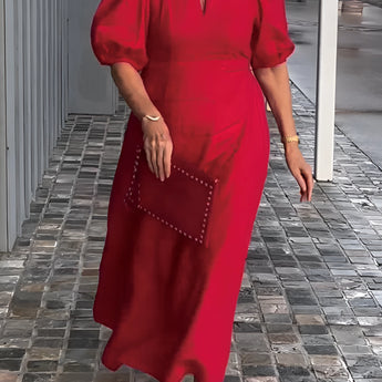 
A red maxi dress with puff sleeves and a square neck, featuring studded pockets. The dress is showcased in a 5XL size.
