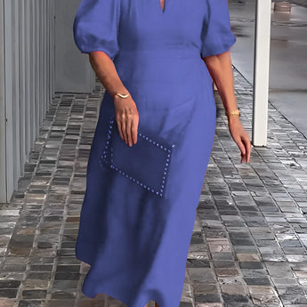 Blue maxi dress featuring puff sleeves, a square neckline, and studded pockets, worn by a person smiling.