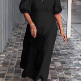 
A person wearing a black red maxi dress with puff sleeves, a square neckline, and studded pockets, standing and smiling with their hands on their waist.