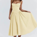 
A woman wearing a vintage-style yellow midi dress with spaghetti straps, suitable for a tea party. The dress features a classic one-piece design and is shown in an XL size.