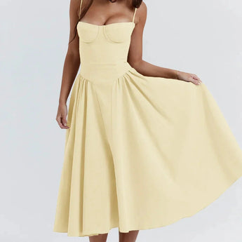 
A woman wearing a vintage-style yellow midi dress with spaghetti straps, suitable for a tea party. The dress features a classic one-piece design and is shown in an XL size.