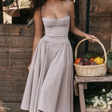A light gray vintage-style tea dress with spaghetti straps and a midi length, suitable for daytime wear. The dress features a fitted waist and a flowing skirt, perfect for casual or formal occasions.
