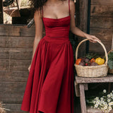 Red midi dress with spaghetti straps, featuring a vintage-style design suitable for tea parties; shown in size XL against a wooden background.