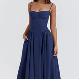 Blue midi dress with spaghetti straps, vintage-style design featuring a fitted waist and flowing skirt, modeled by a woman with long hair, highlighting the dress's elegant and classic tea dress silhouette.