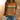 Red multicolor striped crewneck sweatshirt, casual autumn fashion, shown on a person paired with jeans.