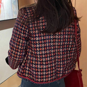 Red and navy fringed women's tweed jacket with chic designer style, featuring a classic tartan pattern, structured shoulder, and elegant neckline.