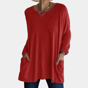 A red oversized tunic sweater for women, featuring long sleeves, a comfortable loose fit, and convenient pockets, ideal for fall fashion. The sweater is styled on a mannequin in a 3XL size, showcasing its relaxed shoulder and round neckline design.