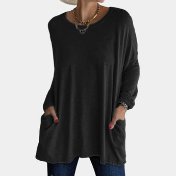 
A black oversized tunic sweater with long sleeves and pockets designed for women's fall fashion, featuring a relaxed fit and comfortable neckline, suitable for plus-size wear.