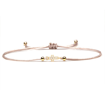 Red string bracelet with a gold charm, adjustable and designed as a lucky and spiritual gift, displayed against a neutral background.