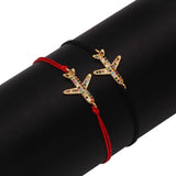 Red string starfish charm bracelet adorned with multicolor crystals on a person's wrist.