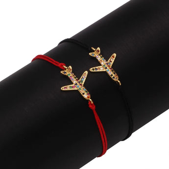 Red string starfish charm bracelet adorned with multicolor crystals on a person's wrist.