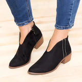 Red suede pointed toe women's ankle booties with a low heel in size 42, shown in a slip-on style. The booties are paired with denim pants, highlighting their sleek design and vibrant color.