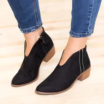 Red suede pointed toe women's ankle booties with a low heel in size 42, shown in a slip-on style. The booties are paired with denim pants, highlighting their sleek design and vibrant color.