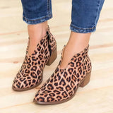 Red suede pointed toe women's ankle booties in leopard print, featuring a slip-on design with a low heel, shown on a model's foot for style reference.