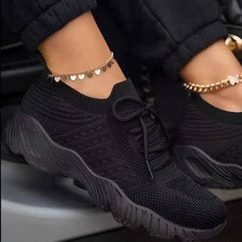 Red women's breathable mesh sneakers, lightweight athletic shoes in Nero color, size 43, displayed in a setting with accessories like sunglasses and body jewelry.