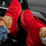 Red women's breathable mesh sneakers in size 43 being worn, showcasing their lightweight and comfortable design. The sneakers are paired with sportswear.