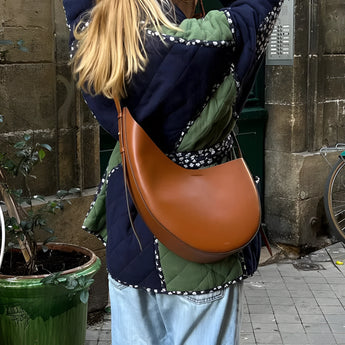 Reversible navy blue quilted kimono jacket with an urban boho style, shown worn by a person posing next to a plant and flowerpot.