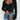 Ribbed black square neck top paired with high waist denim jeans, accessorized with a mini bag.