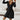 Ribbed black wrap dress with long sleeves and a V-neck in a skater style, showcasing the garment's fitted waist and flowy skirt.