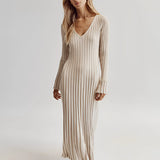 Ribbed V-neck cream maxi sweater dress with long sleeves, featuring a fitted waist and a flowing silhouette reaching down to the knees, perfect for fall fashion.