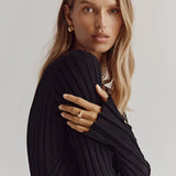 Cream-colored ribbed V-neck maxi sweater dress with long sleeves, perfect for fall fashion, worn by a person with shoulder-length hair.