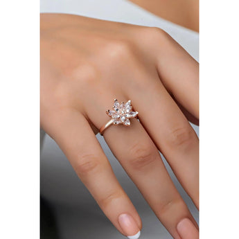 A rose gold marquise diamond flower engagement ring with a nature-inspired design displayed on a hand.