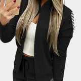
Women's rose gold velvet tracksuit with sequin detail, featuring long sleeves, a high neck, and waistband. The tracksuit is worn by a model with layered hair, shown in a black and XL variant, capturing a luxury activewear style.